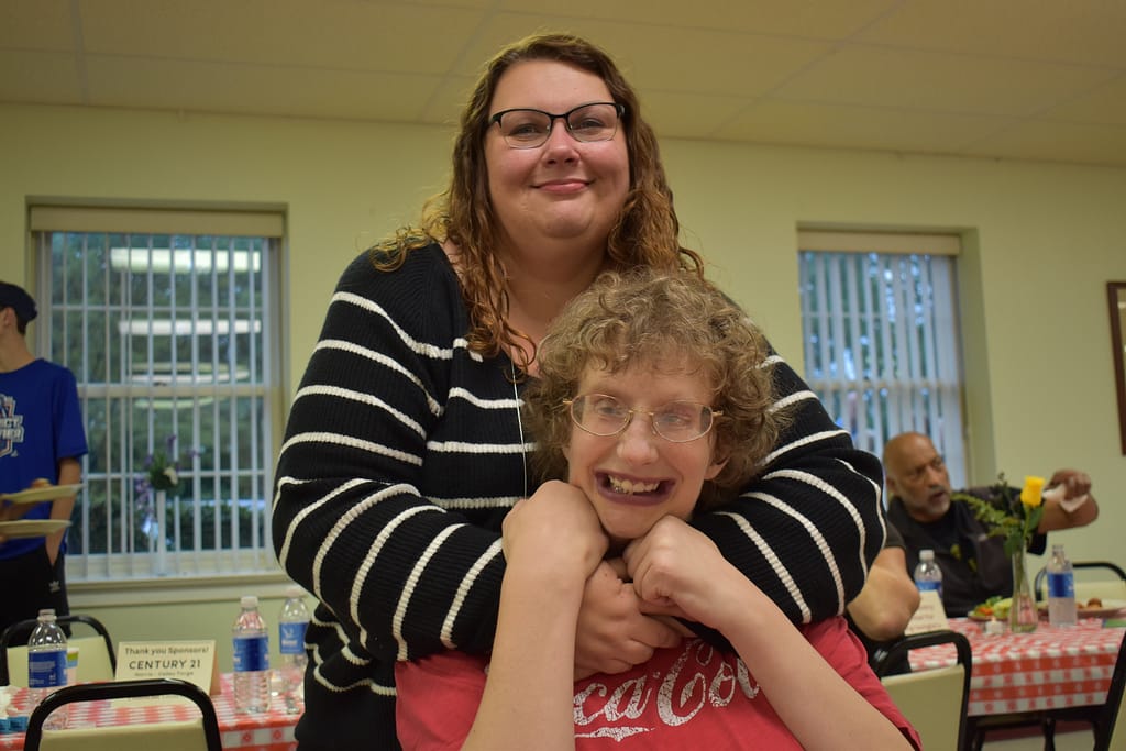 A female advocate hugs her female partner at our annual Spaghetti Dinner