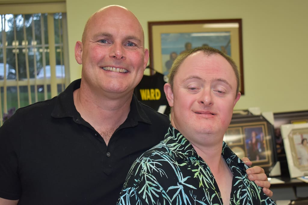 A male advocate stands next to his male partner at our annual Spaghetti Dinner